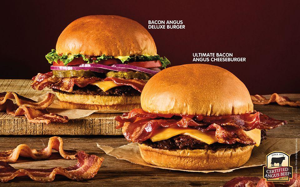 A graphic of a bacon angus deluxe burger and ultimate bacon angus cheeseburger with bacon strips on a dark background