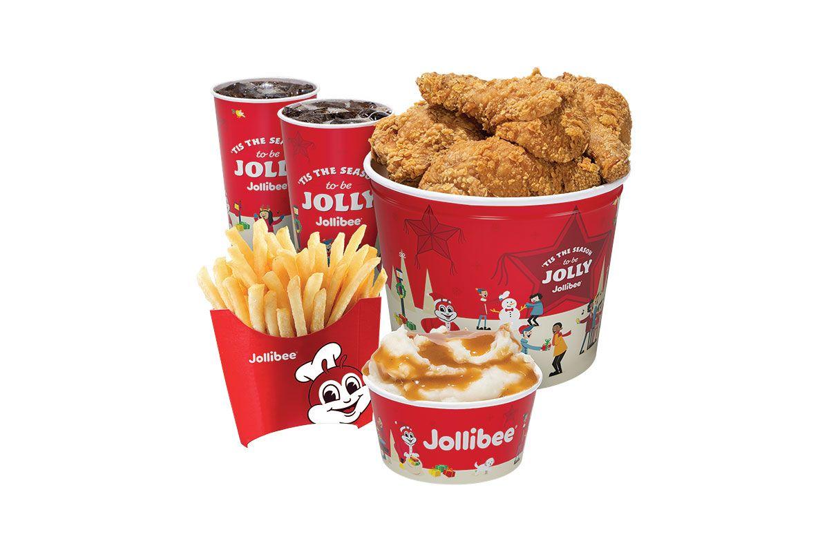 A picture of a bucket of fried chicken with fries, mashed potato, and fountain drinks on a white background